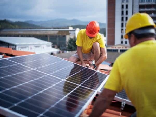 due tecnici installano un impianto fotovoltaico certificato