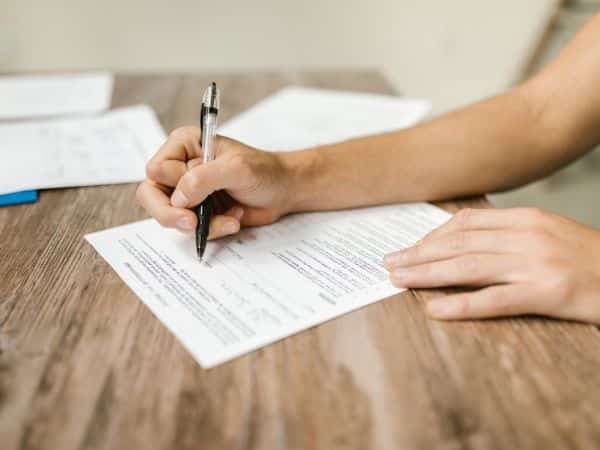 mano che firma un foglio di certificazione pannelli fotovoltaici