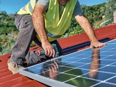 uomo fa la manutenzione di un impianto fotovoltaico su tetto