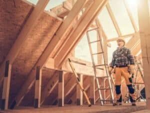 Lavori di costruzione di una casa in legno con un operaio